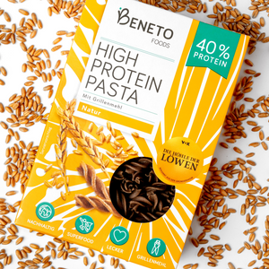 Die Beneto Pasta Verpackung in der Sorte Natur liegt in einem Bett aus Dinkelkörnern.